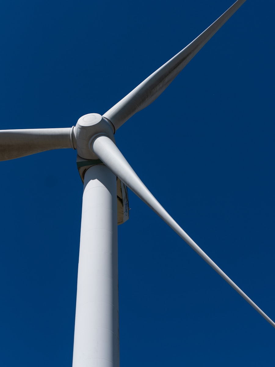 A close up of a wind turbine against a blue sky